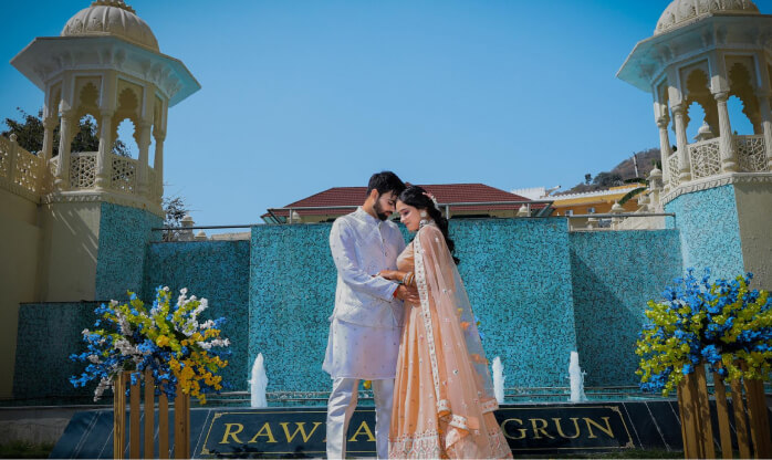 Couple at a heritage palace venue with blue tiled fountains for a destination wedding in India