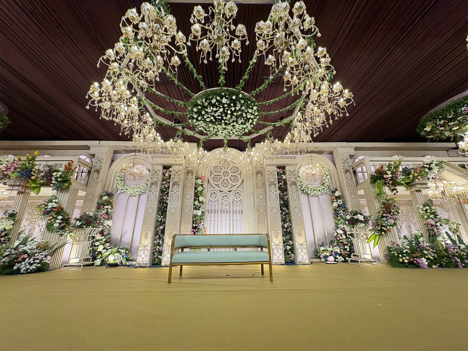 Luxury wedding venue with a crystal chandelier stage and white floral décor