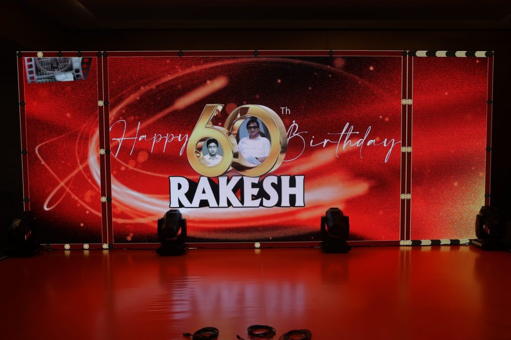 Rakesh’s 60th birthday celebration stage with a red backdrop