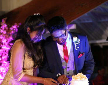 Joel and Nisha cutting their wedding cake at their reception in Bangalore