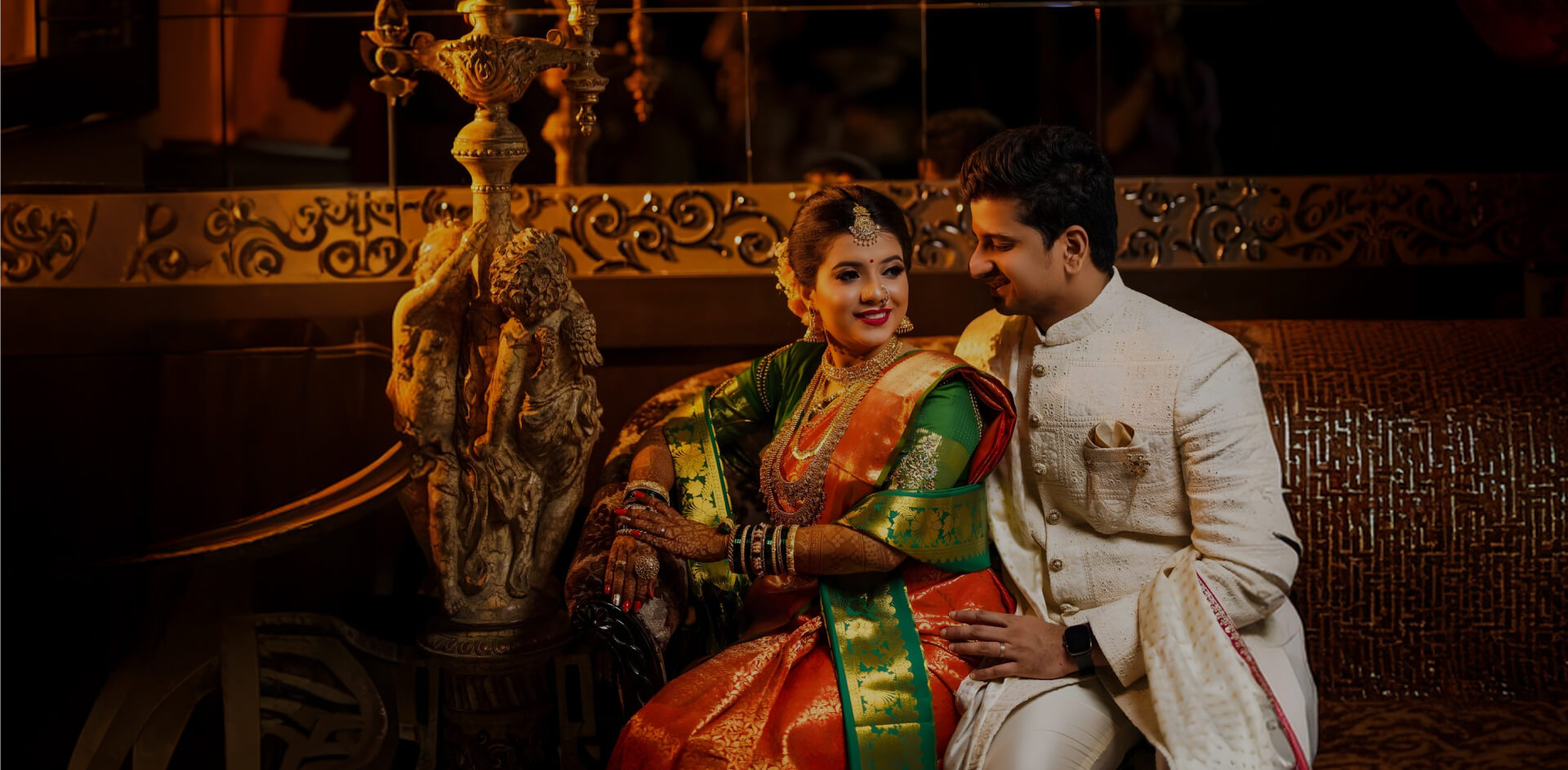 Bride in a silk saree and groom seated on a decorated wedding stage, planned by WDC wedding planners in India