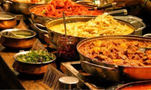 Indian curries and rice served in copper pans by wedding caterers