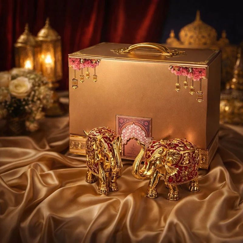 Gold boxed wedding invitation with pink floral tassels and jewelled elephant figurines